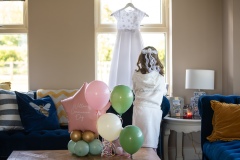 First Communion dress hanging in natural morning light before the family celebrations began.