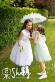 First Communion photography with Hailey and her sister Willow, whispering something into her ear