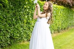 First Communion photography of Hailey on the lawn at home before her ceremony.