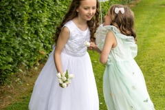 First Communion photography with Hailey and her sister Willow, whispering something into her ear