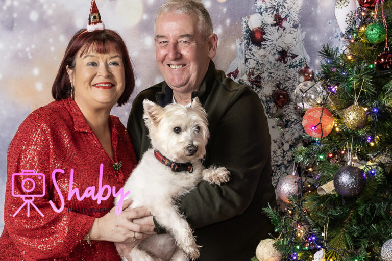 Fun and festive Christmas family portrait by Shaby Photography, capturing a smiling family in holiday attire, enjoying a playful and joyful photography session with a seasonal backdrop