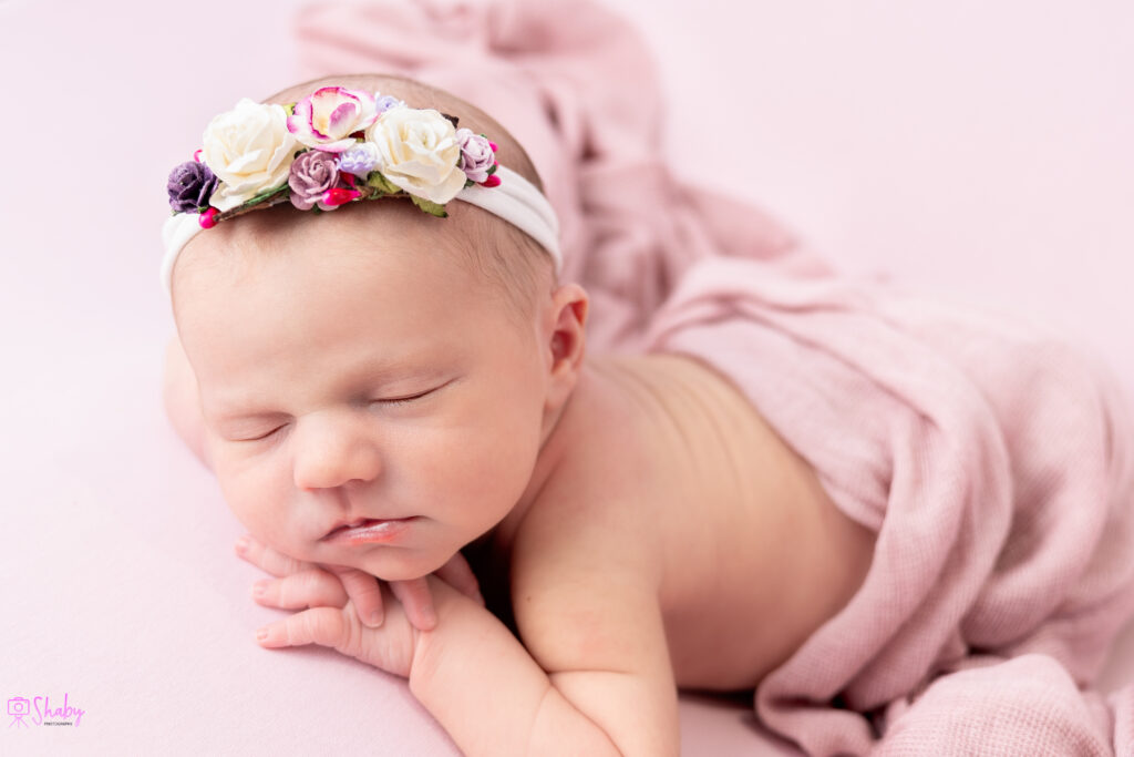 Newborn baby girl Nora sleeping peacefully with a gentle smile, during a professional photography session in Ireland. Shaby.ie, Newborn and Children photgrapher based in Meath