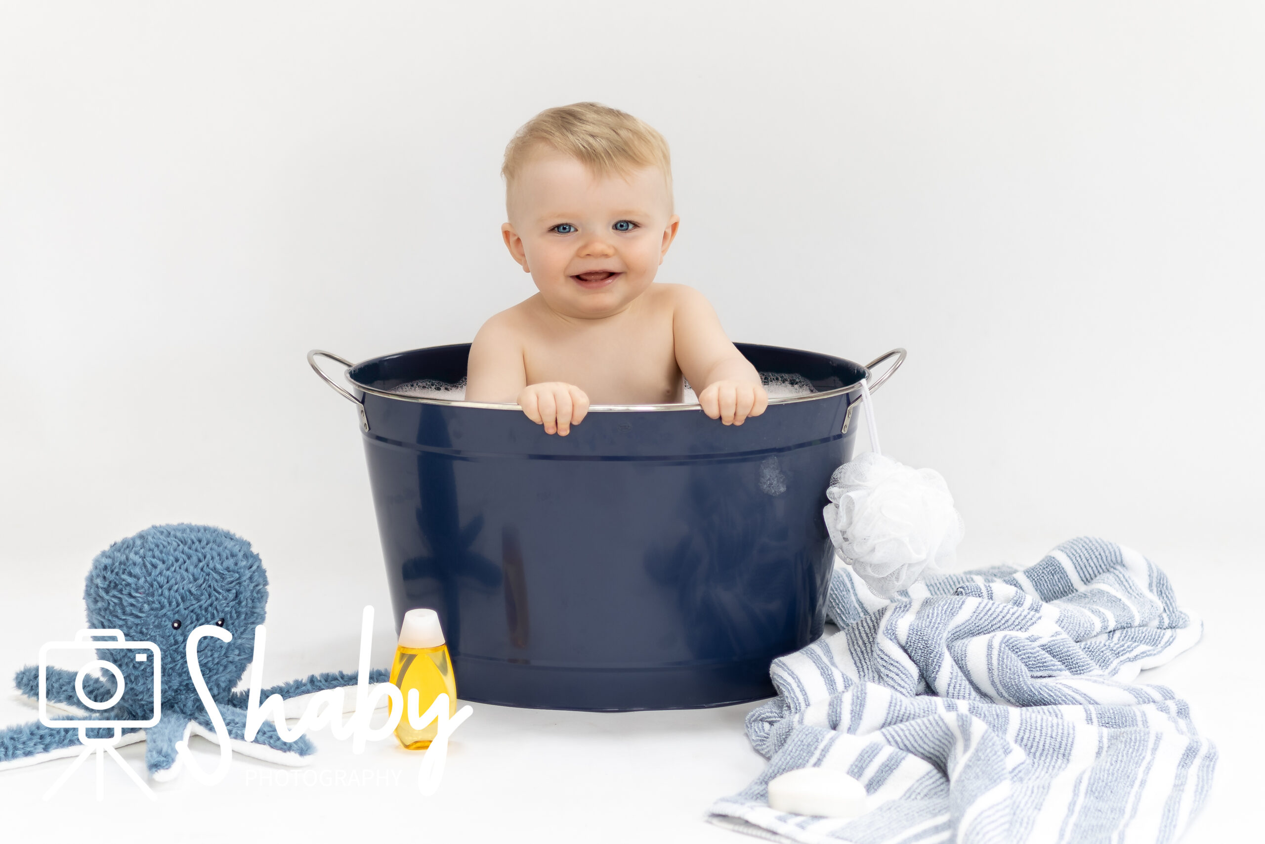 Photo from baby photography session or photoshoot of a beautiful baby boy, posing in a bath, by www.shaby.ie