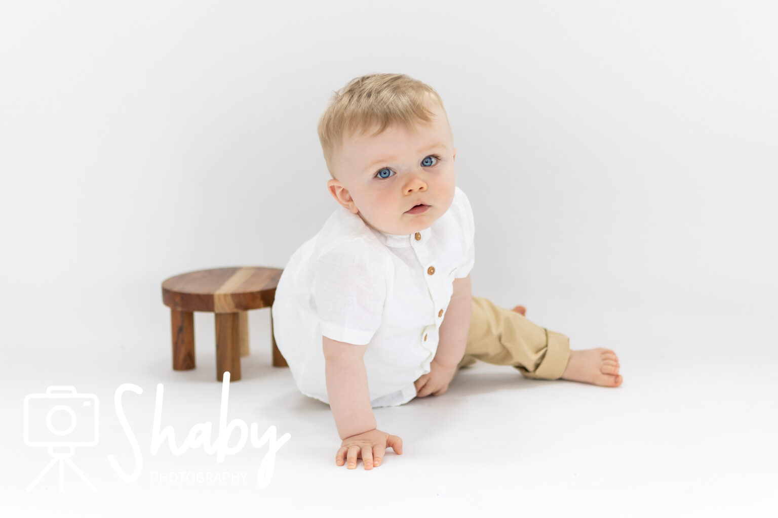 Photo from baby photography photoshoot of a beautiful baby boy, posing on a white background with a photography prop, by www.shaby.ie