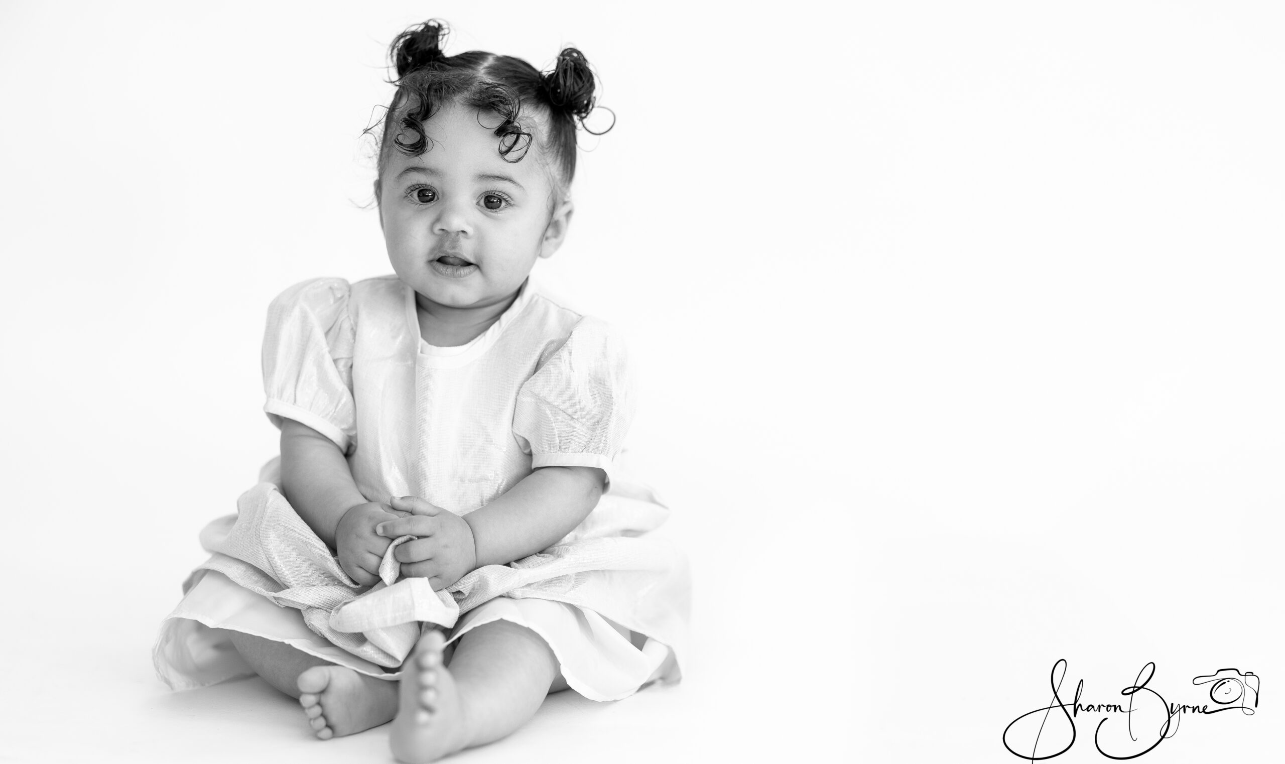 Smiling 10-month-old baby during a toddler photoshoot.