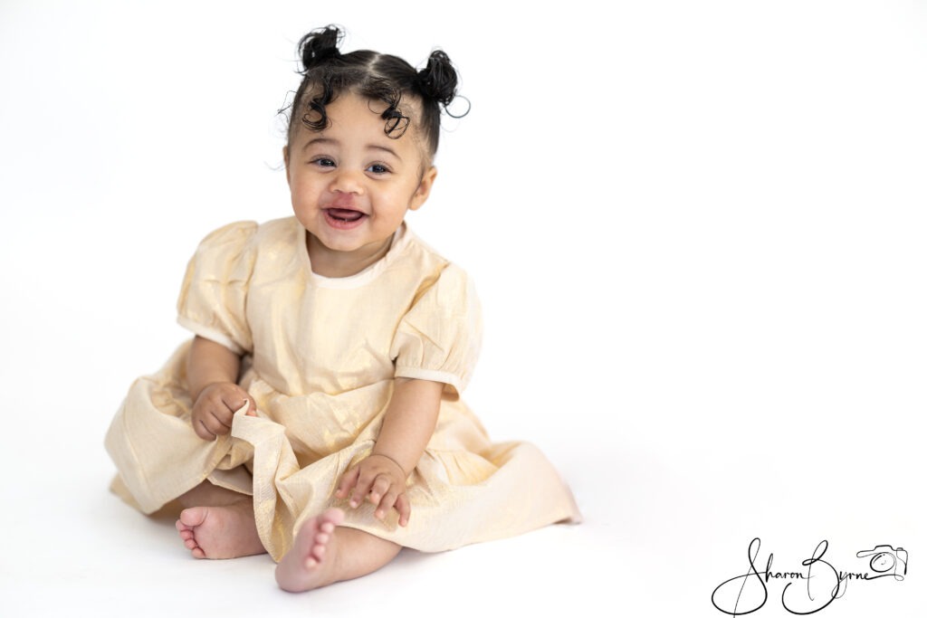 Smiling 10-month-old baby during a toddler photoshoot.