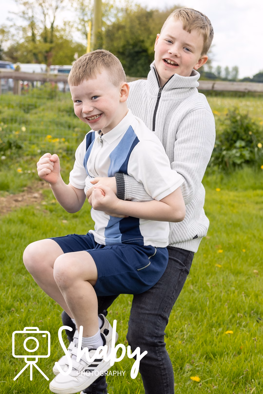 Family portrait photo taken of 2 brothers playing in the garden