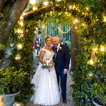 Lorraine and Gavin share a moment after the ceremony, framed by a beautiful woodland and twinkling lights. Wedding photography by Sharon Byrne.